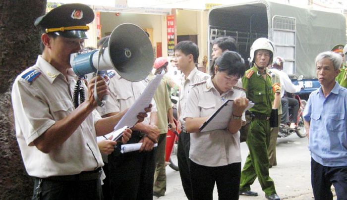 Cán bộ thực hiện thi hành án dân sự tại một cơ sở ở Hà Nội